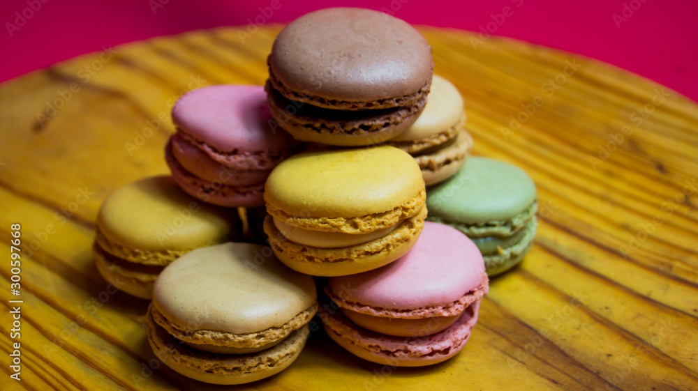Fototapeta premium Colored macarons isolated on wooden dish, typical French dish