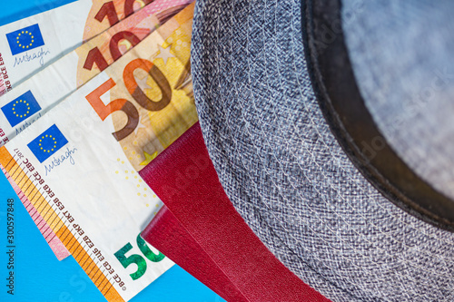 Travel Trip background flat lay. Old gray hat, passport and cash money on blue background. Beautiful summer concept for travel and summer vacation. photo