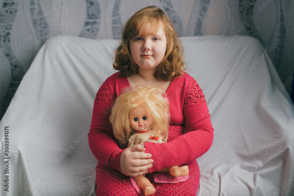 Portrait of lovely little girl sitting on bed with her loving doll Portrait of lovely little girl sitting on bed with her loving doll