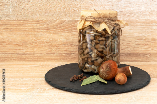 Marinated honey fungus mushrooms in a bowl on the plateblack. On wooden background. photo