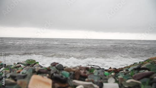 The famous beach with glass fragments stones in Russky Island, Vladivostok. Waves come to land. Environmental pollution