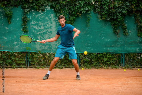 Skilled and agile tennis player having a practice at outdoor court. © yuriygolub