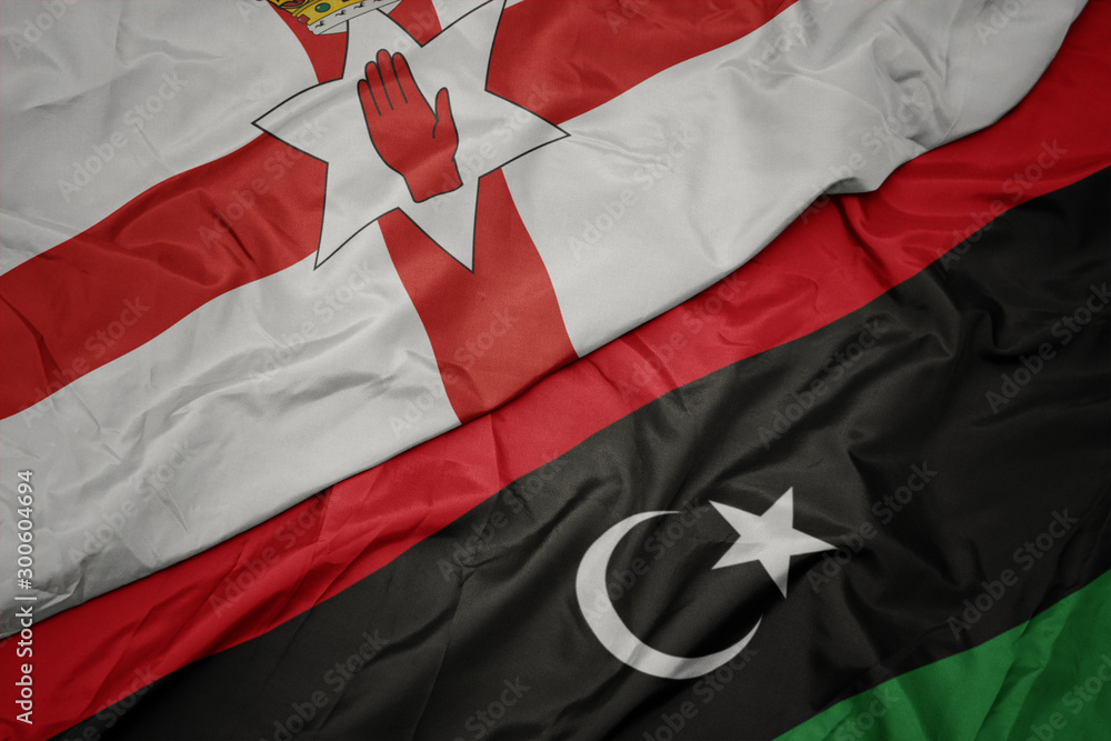 waving colorful flag of libya and national flag of northern ireland. waving colorful flag of libya and national flag of northern ireland.