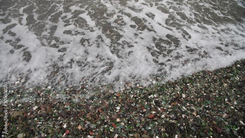 The famous beach with glass fragments stones in Russky Island, Vladivostok. Waves come to land. Environmental pollution