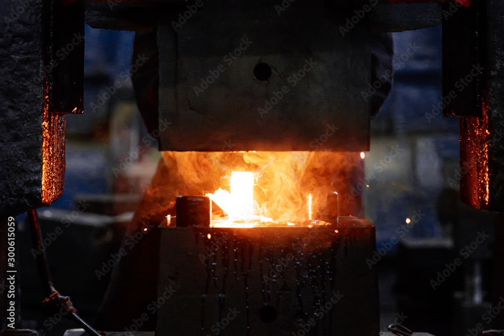 metal forging, forging shop. hydraulic hammer shapes the red-hot billet. the production of high-tech parts