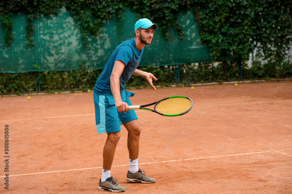 Man playing tennis at outdoor court.