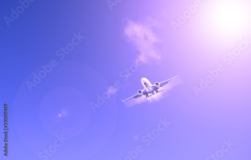 Airliner against the blue sky. The sun shines.