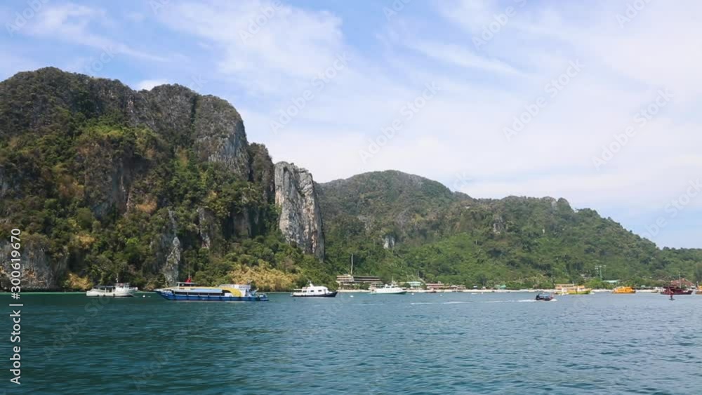 Views of the mountains, tropical island, port and speedboats and boats passing by. shooting from water. Views of the mountains, tropical island, port and speedboats and boats passing by. shooting from water.