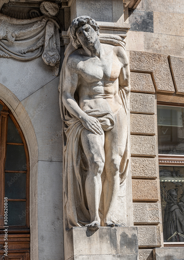 Obraz premium Statue of powerful and emotional atlas of Renaissance Era as support for building facade in Dresden, Germany, details, closeup