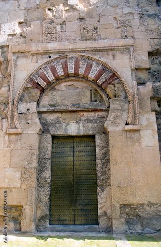 An ornate and elaborate door and arch at the Mezquita of Cordoba in Spain. The building is a fine example of Moorish  Islamic construction. Intricate patterns are formed with the brick and masonry.