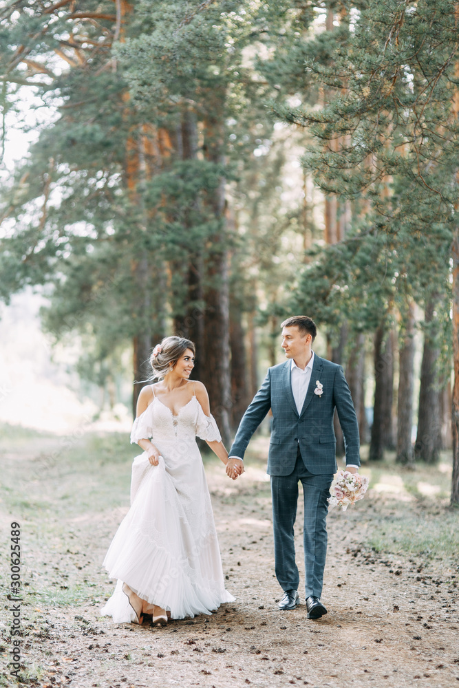 Stylish European wedding at sunset. Happy couple in the forest in nature.