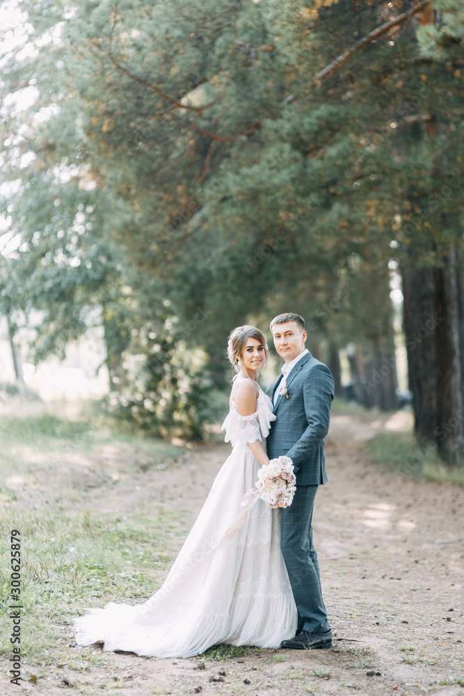 Stylish European wedding at sunset. Happy couple in the forest in nature.