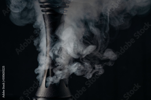 Smoking hookah on dark wooden background,. close up photo