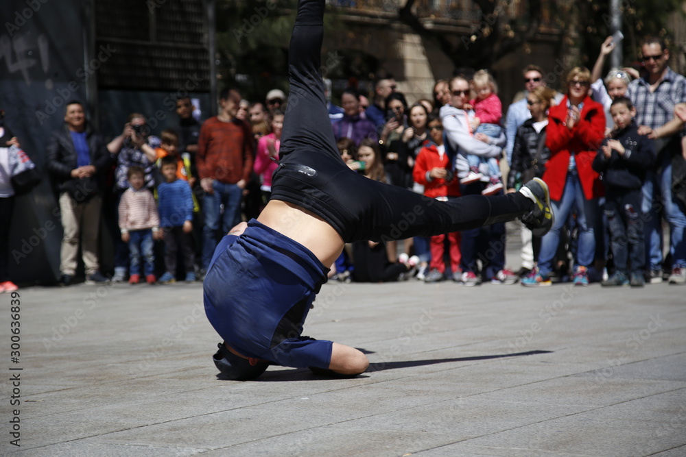 Naklejka premium Barcelona, Catalonia / Spain »; December 2017: A young man in blue dancing Break Dance in the city of Barcelona in the Cathedral Square