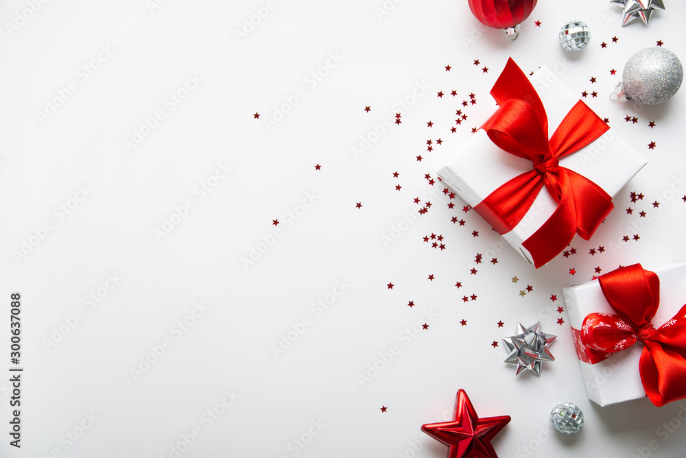 Christmas and New Year holiday background. Xmas greeting card. Christmas red ribbon gifts and ornaments on white background top view. Flat lay Christmas and New Year holiday background. Xmas greeting card. Christmas red ribbon gifts and ornaments on white background top view. Flat lay