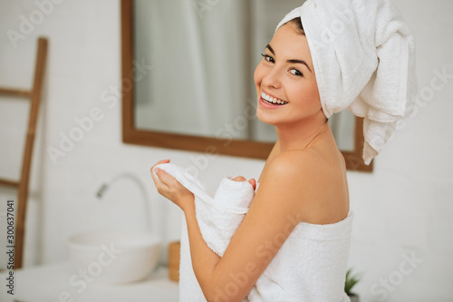 Cuadro en lienzo pretty young woman wraps her body in white towel in bathroom