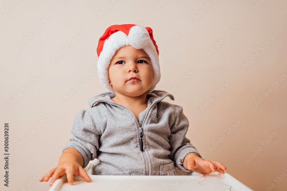 baby in Christmas bonnet dressing up the doll , on white background. copy space baby in Christmas bonnet dressing up the doll , on white background. copy space
