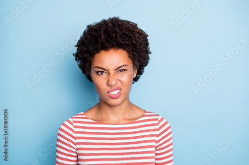 Ugh. Closeup photo of pretty unhappy dark skin lady disgusted with awful eat look expressing disagreement wear striped shirt isolated blue color background