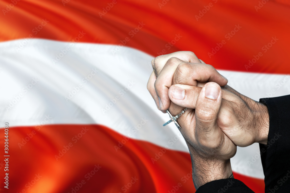 Austria flag and praying patriot man with crossed hands. Holding cross, hoping and wishing.