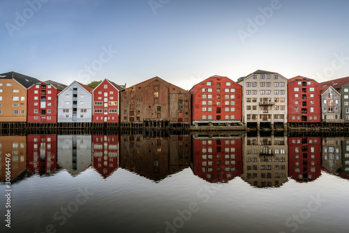 Unesco world heritage site of old ancient wooden buildings by the river of Nidelva in Trondheim. Reflections, buildings, ancient, norway, travel, explore concept.