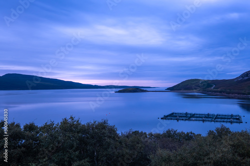 Salmon farms amidst gorgeous landscapes in the far north of the Scottish highlands along the iconic NC500 coastal route