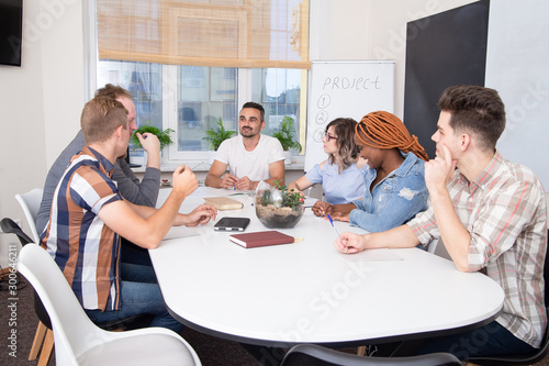 A group of people at a business training listens to the speaker or chief. Teamwork in an international IT company, students on seminar