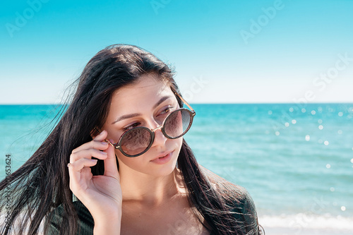 Portrait of girl by sea. Woman in bodysuit with long sleeves.