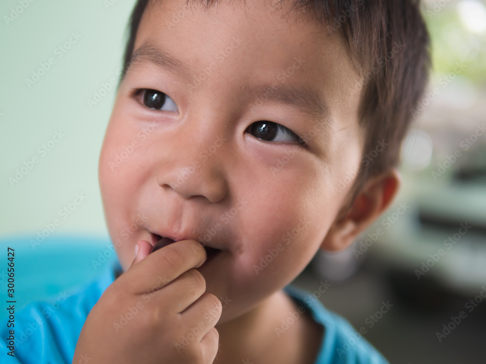 Asian child boy in blue t shirt eating grape in mouth at home with happy smiling face on blue chair,food time,healthy concept. Asian child boy in blue t shirt eating grape in mouth at home with happy smiling face on blue chair,food time,healthy concept.