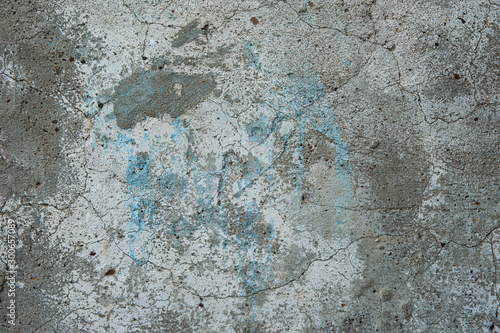 Abstract background. An old rough texture, a gray concrete wall with patches of light blue paint. Background, structure.