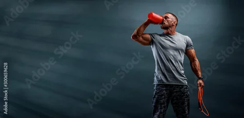 Obraz Suplement diety Muskularni mężczyźni piją białko, napój energetyczny po treningu