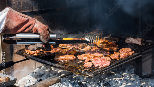 Beef meat with polenta and sausages cook on the barbecue flame, viewed from above