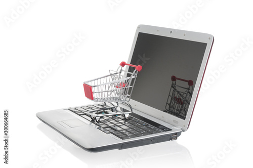 Shopping trolley on laptop on white background