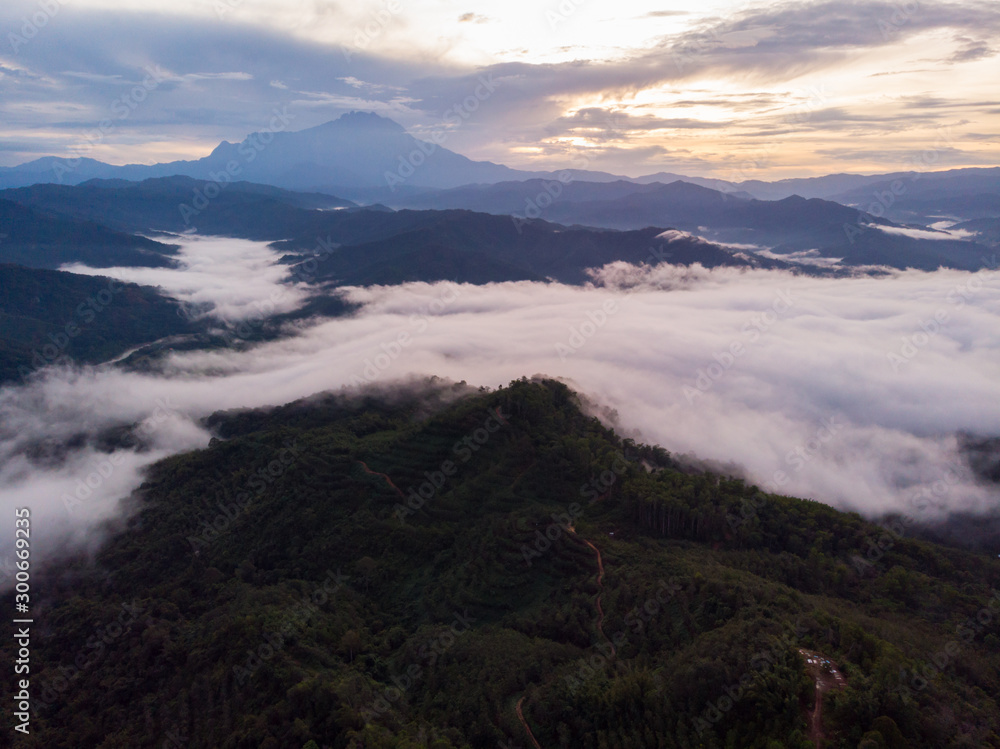 Rural landscape with dramatic sea of cloud during sunrise with Mount Kinabalu at Saba, Borneo