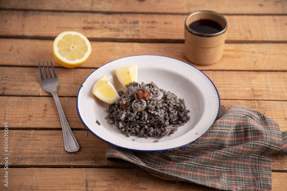 Plate of black rice with squid and prawns or Valencian black paella Plate of black rice with squid and prawns or Valencian black paella