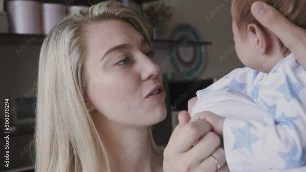 Happy young family - mom and dad holding their new born son, kissing and hugging. Happy family concept. Happy young family - mom and dad holding their new born son, kissing and hugging. Happy family concept.