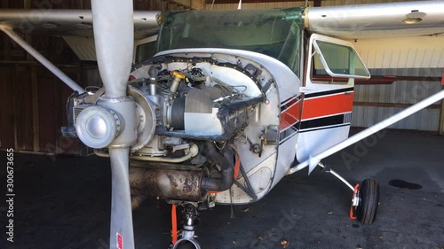 Moving shot of a small airplane with it's cowling off in the process of repair. photo