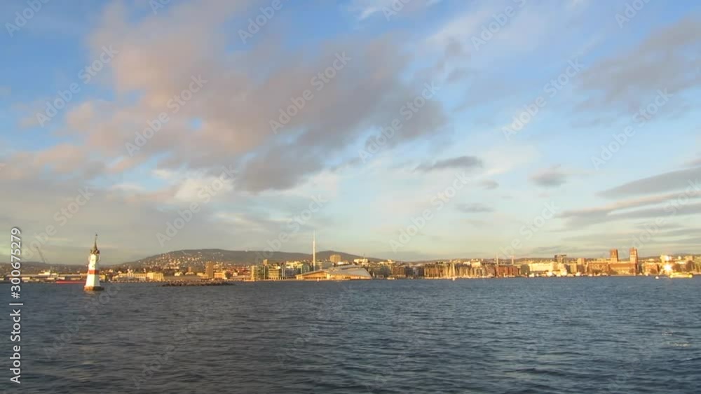 View of Oslo, Norway from a moving boat at sunset in winter View of Oslo, Norway from a moving boat at sunset in winter