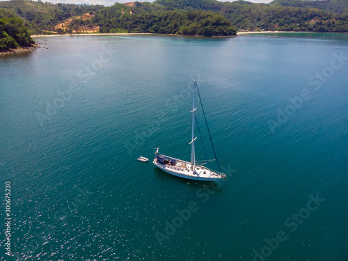 Aerial view of white Yacht in deep blue sea with beautiful landscape view in Kuala Abai, Kota Belud, Sabah, Malaysia