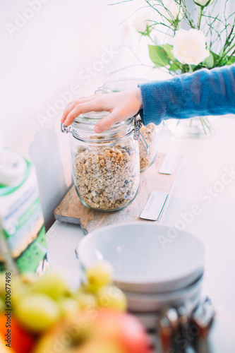 hand reaching for a bowl of cereal to have breakfast in a hotel or bed & breakfast