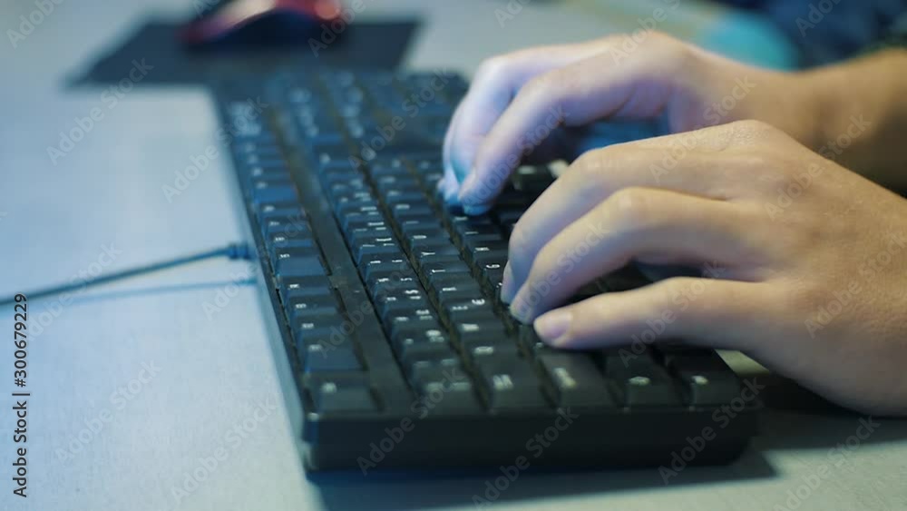 Man's hands typing on PC keyboard in the office. Evening time, static shot, keyboard on the gray desk, Man fast typing close up Man's hands typing on PC keyboard in the office. Evening time, static shot, keyboard on the gray desk, Man fast typing close up