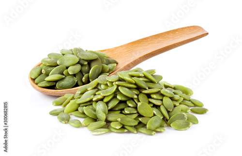 Fotografi Pumpkin seeds in wood spoon  isolated on a white background