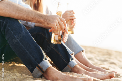 Lovely smiling young couple drinking beer