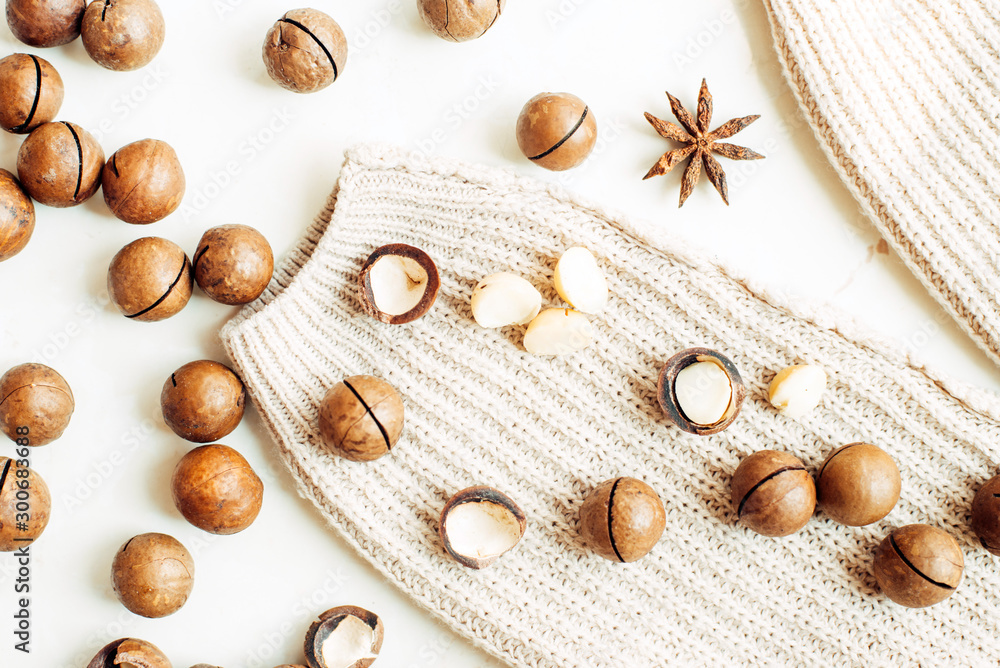 Macadamia nuts, star anise and warm sweater. Top view flat lay.