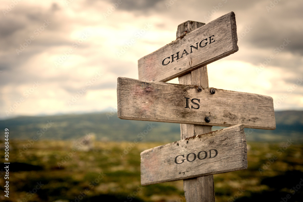 Change is good quote on wooden signpost in nature with moody background. Motivational, move on, changes, choice, choices concept.