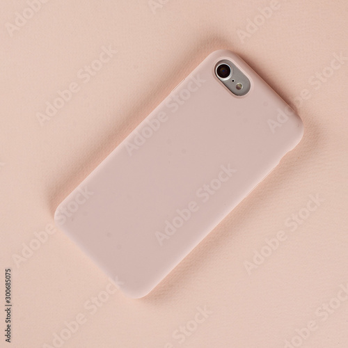 Cell phone in pink case on paper background