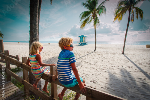 Fotografie boy and girl looking at tropical beach with palms, family on vacation in Florida