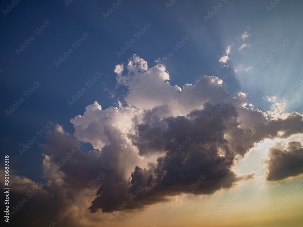 A group of beautiful clouds of gray shades in the rays of sunset against a blue sky. A group of beautiful clouds of gray shades in the rays of sunset against a blue sky.
