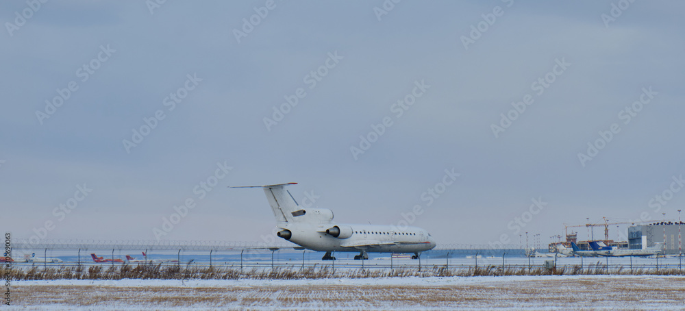 Plane at the airport on the runway in winter. Aircraft winter runway
