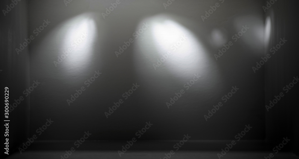 Obraz premium Spotlight light illuminates the empty black room.