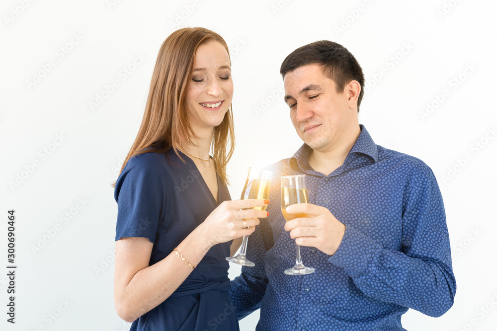 Man and woman celebrating Christmas or New Year eve party with glasses of champagne on white background Man and woman celebrating Christmas or New Year eve party with glasses of champagne on white background